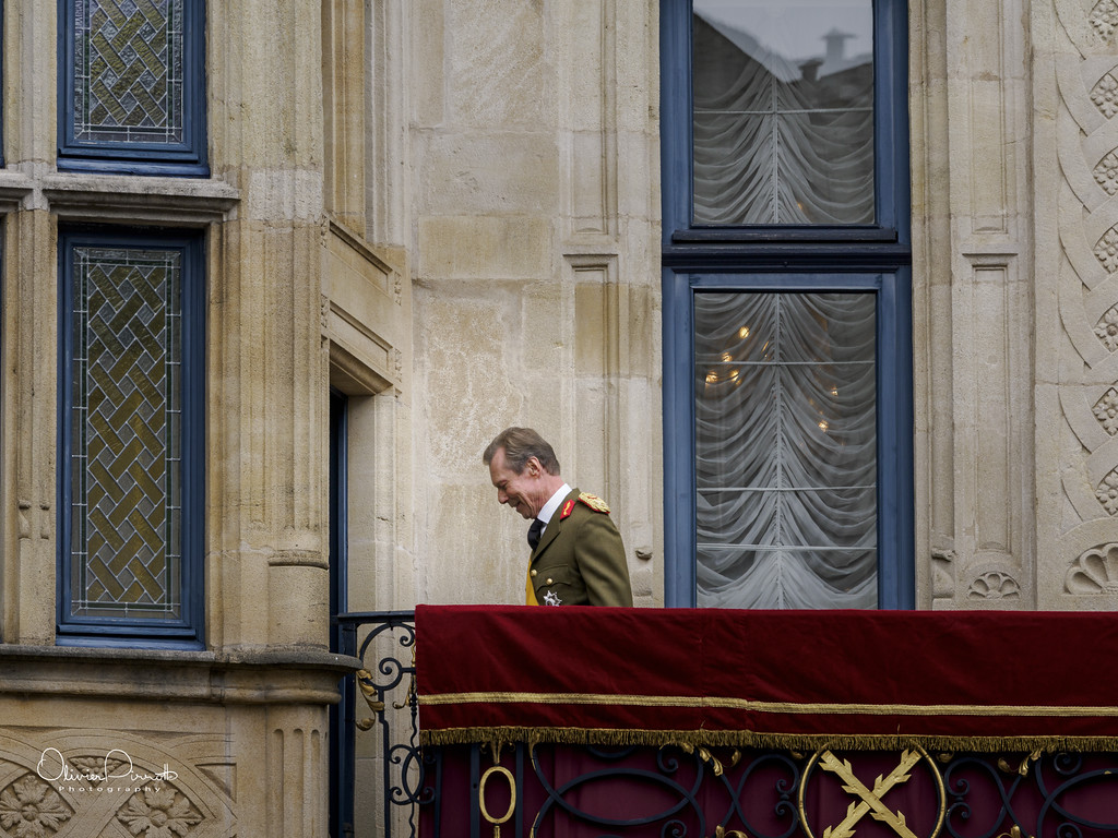 Uniformed man walking along a balcony on a historic building