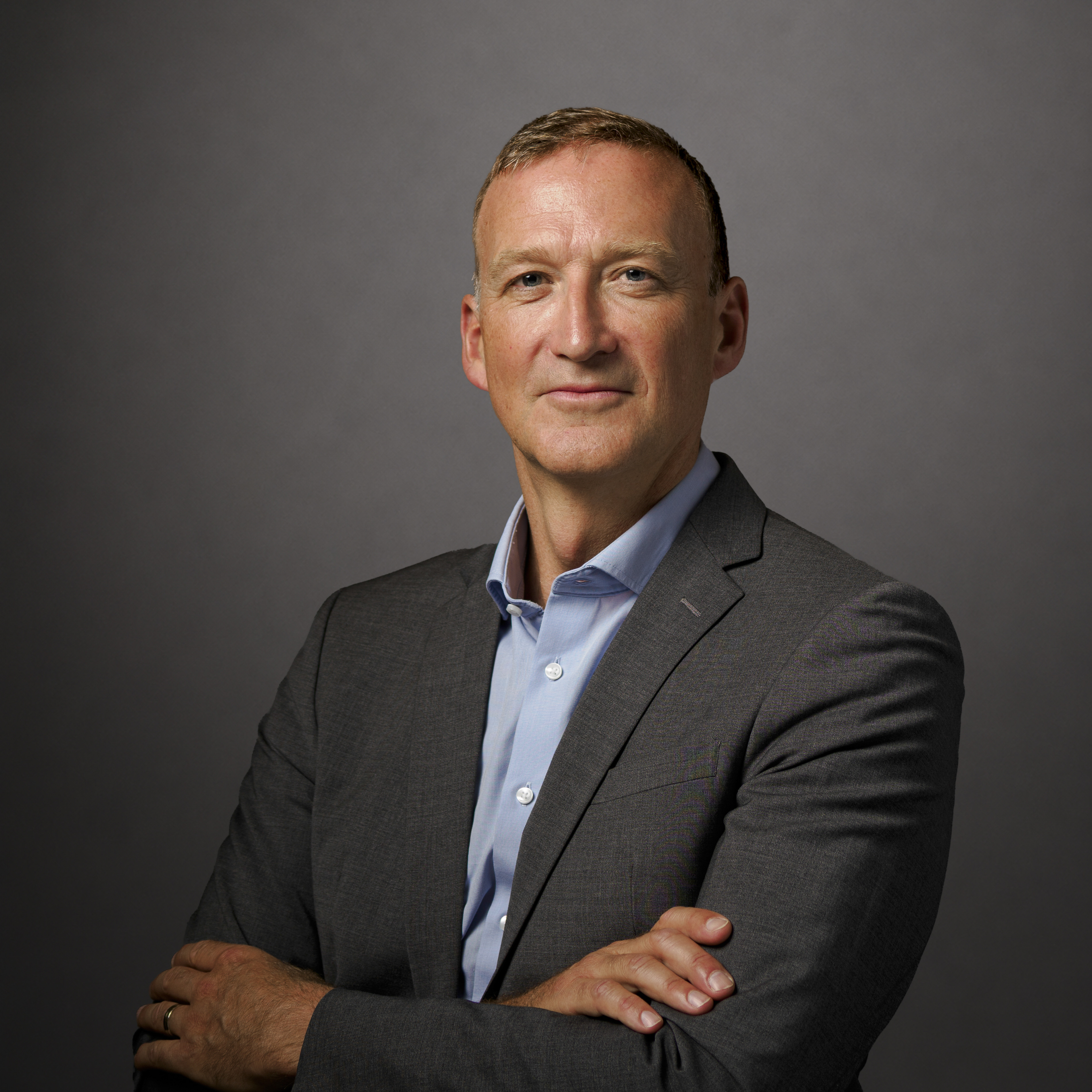 Professional studio headshot of a man in a suit